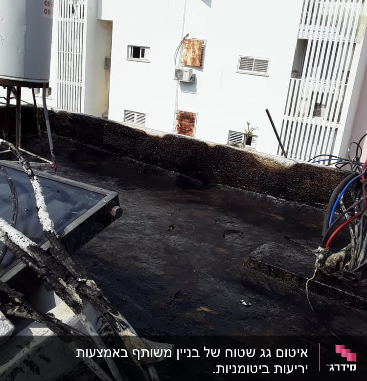 גג אטום בזפת עם צינורות חשמל חשופים